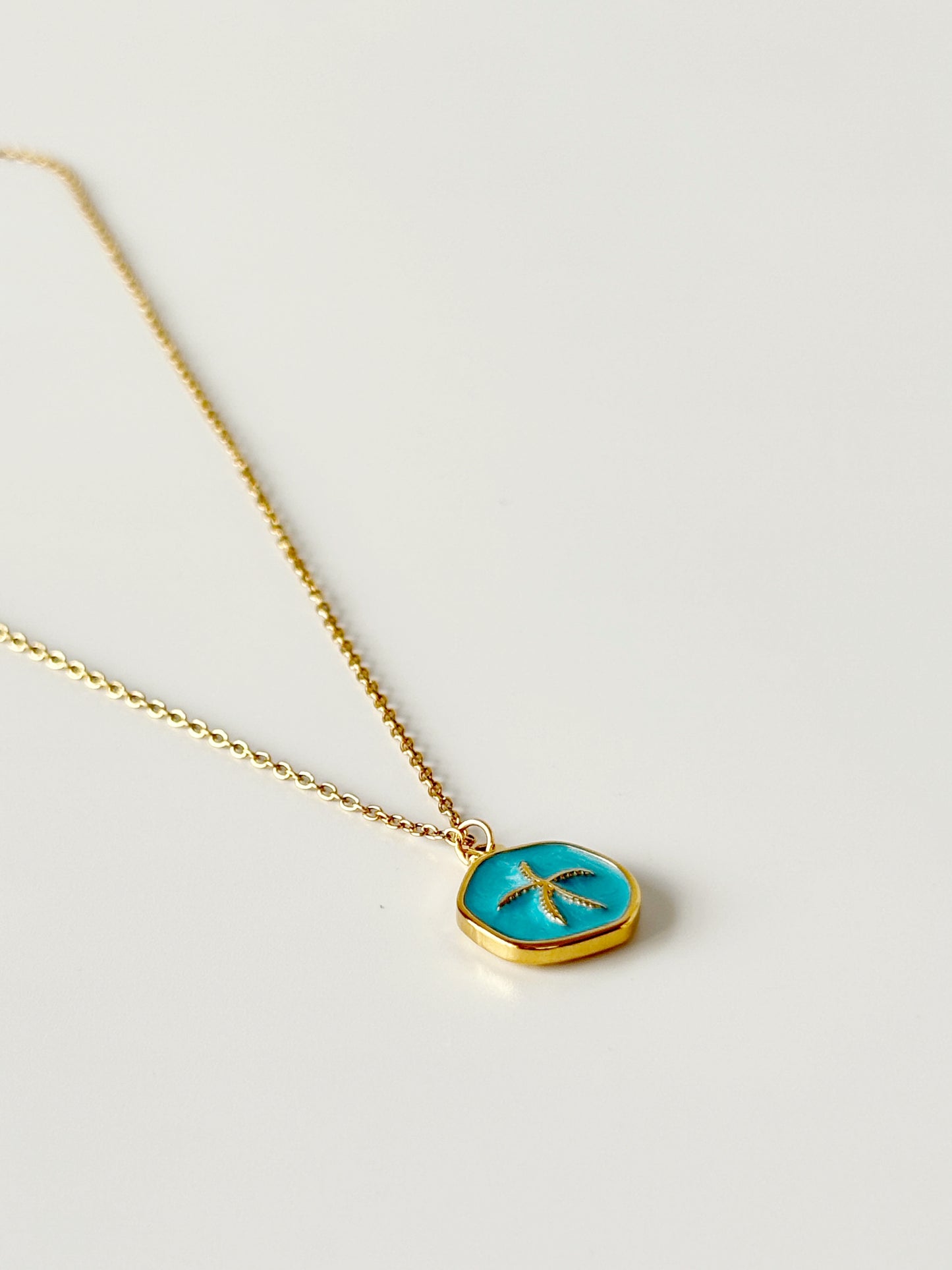 Necklace with a turquoise pendant on a light gray background