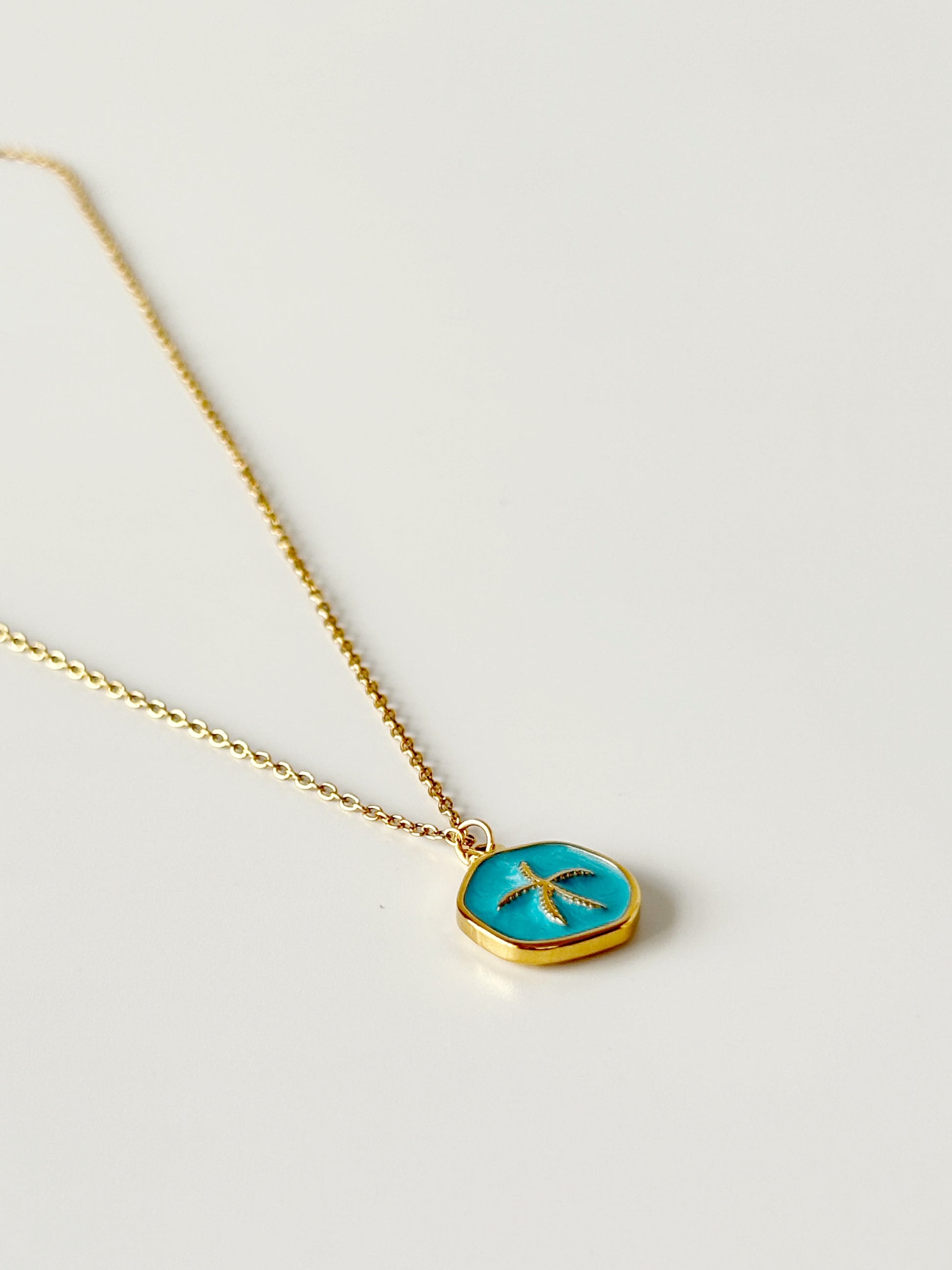 Necklace with a turquoise pendant on a light gray background