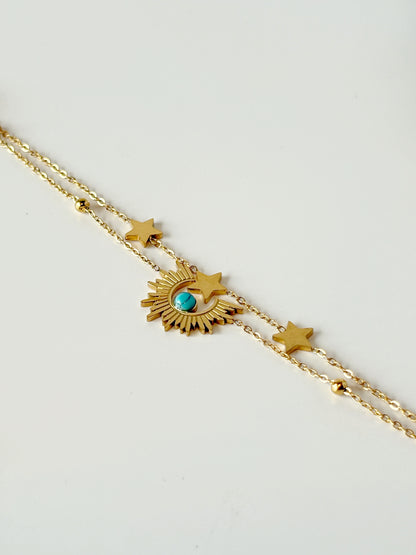 Gold necklace with star and eye-shaped pendant on a light gray background