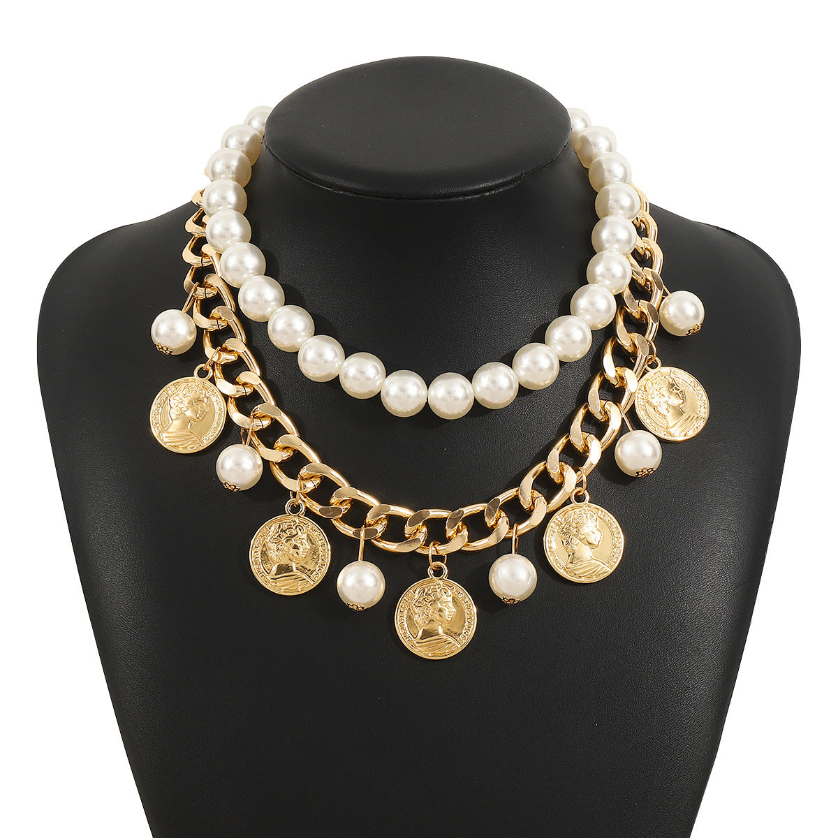 Necklace with pearls and gold coins on a black mannequin bust