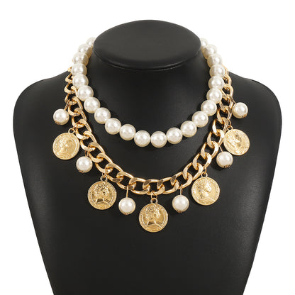 Necklace with pearls and gold coins on a black mannequin bust