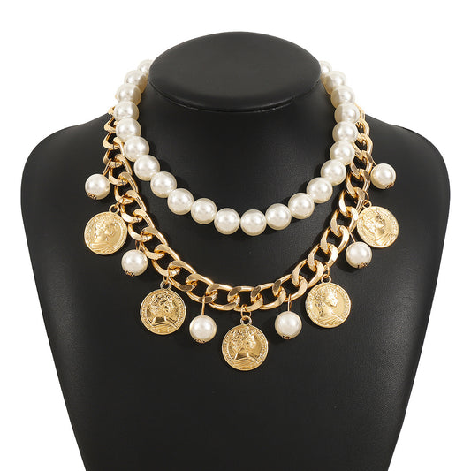 Necklace with pearls and gold coins on a black mannequin bust