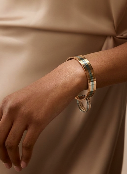 Gold and silver stack bangles worn on a hand