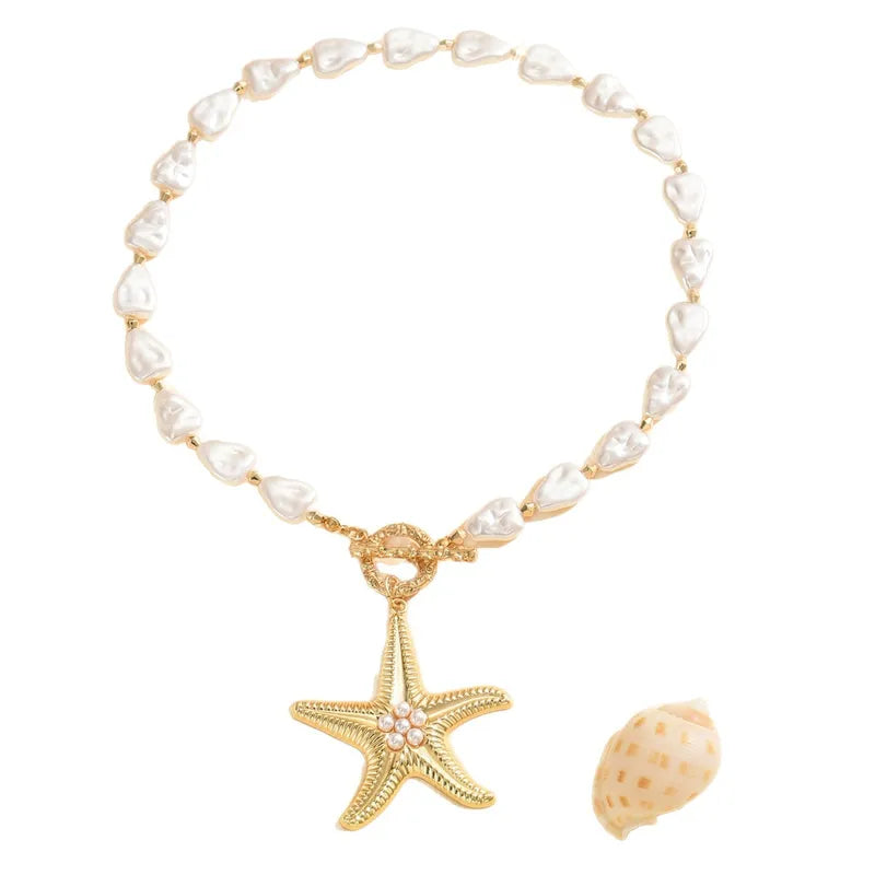 Pearl necklace with gold starfish charm and shell on a white background