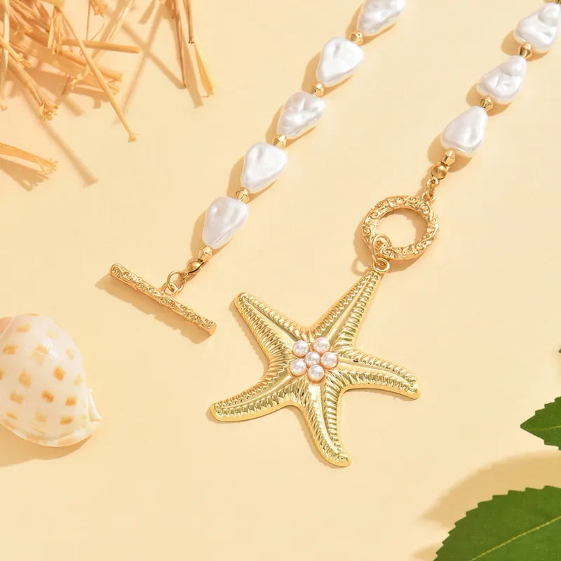 Gold starfish pendant necklace with pearls on a yellow background
