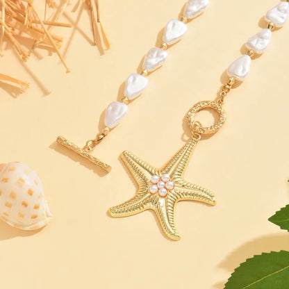 Gold starfish pendant necklace with pearls on a yellow background