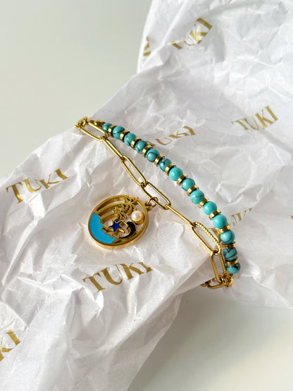 Turquoise beaded bracelet with gold accents on TUKI branded paper